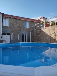 a swimming pool in front of a house at Casa da Aldeia in Santa Cruz do Douro