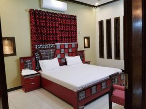 a bedroom with a bed and a red wall at Hotel Moon Light view in Lahore