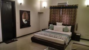 a bedroom with a bed and a window at Hotel Moon Light view in Lahore +1 photo