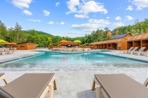 a swimming pool with chairs and umbrellas at a resort at LakeSides Retreat with Amenities in Hollister