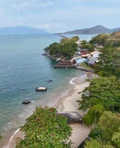 a view of a beach with trees and the ocean at J U N Q U E I R A i in Mangaratiba