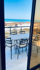 a table and chairs on a balcony with the ocean at La vague in Île Pilau +8 photos