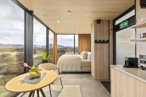 a room with a kitchen and a bedroom with a bed at ÖÖD Hekla Horizon - Mirror Houses in Hella