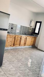 an empty kitchen with wooden cabinets and a window at La vague in Île Pilau