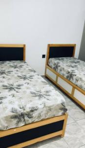 two beds sitting next to each other in a room at La vague in Île Pilau