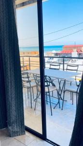 a view of a table and chairs from a window at La vague in Île Pilau