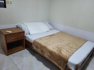 a small bed in a room with a night stand at Serenity Appartementen 2 in Paramaribo