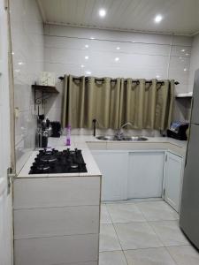 a kitchen with a sink and a stove top oven at Serenity Appartementen 2 in Paramaribo