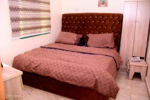 a bedroom with a large bed with a large headboard at MF Supreme Hotels and suites in Ikorodu