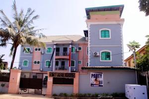 a pink and purple building with a palm tree at MF Supreme Hotels and suites in Ikorodu +18 photos