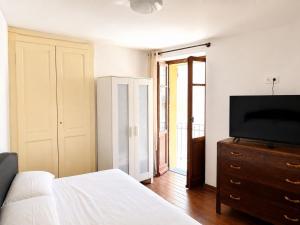 a bedroom with a bed and a television on a dresser at Ca' Santa Maria in Santa Maria Maggiore