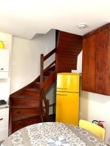 a kitchen with a yellow refrigerator and a staircase at Ca' Santa Maria in Santa Maria Maggiore