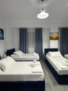 a bedroom with two beds and a light fixture at Nivro in Delvinë