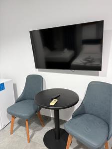 a table and two chairs and a tv at Nivro in Delvinë
