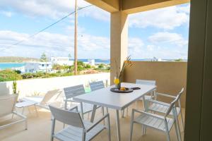 a white table and chairs on a balcony with the ocean at Villa Artemis 2 - Etheras Properties in Kythira
