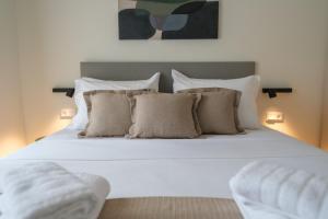 a bed with white sheets and pillows in a bedroom at Villa Artemis 2 - Etheras Properties in Kythira