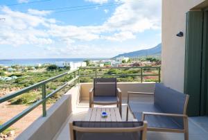 a balcony with chairs and a table and the ocean at Villa Artemis 2 - Etheras Properties in Kythira