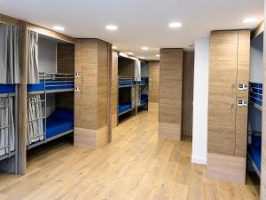 a row of bunk beds in a locker room at CH Arzúa Pilgrim Hostel in Arzúa