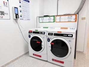 two washing machines sitting next to a wall at CH Arzúa Pilgrim Hostel in Arzúa