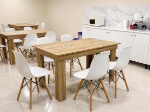 a kitchen with two wooden tables and white chairs at CH Arzúa Pilgrim Hostel in Arzúa +23 photos