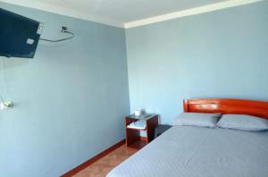 a bedroom with a bed and a tv on the wall at El REFUGIO DE MIS SUEÑOS in Yungay +19 photos