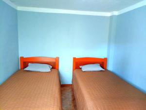 two beds in a room with blue walls at El REFUGIO DE MIS SUEÑOS in Yungay