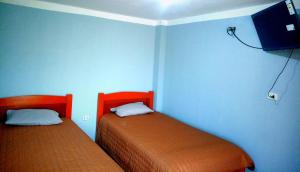two beds in a room with blue walls at El REFUGIO DE MIS SUEÑOS in Yungay