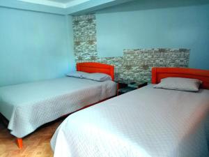 a bedroom with two beds and a stone wall at El REFUGIO DE MIS SUEÑOS in Yungay