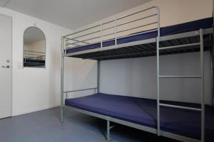a bedroom with two bunk beds with purple sheets at Kammak Hostel Sisimiut in Sisimiut