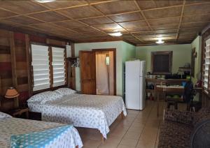 a room with two beds and a refrigerator at The Village Inn in Placencia