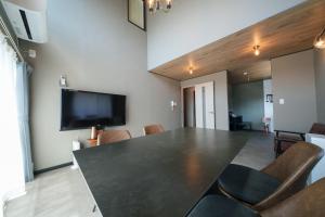 a dining room with a large black table and chairs at plus81 OTARU Entire House 9min Walk from Minami Otaru Station in Otaru