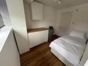 a small bedroom with a bed and a kitchen at Cosy in Windsor in Windsor
