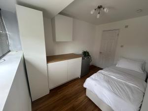 a small bedroom with a bed and a kitchen at Cosy in Windsor in Windsor