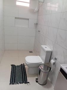 a bathroom with a toilet and a trash can at Pousada Do Goiano in Manhã