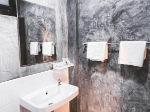 a bathroom with a sink and white towels at Na Sukhothai Hotel in Sukhothai +19 photos
