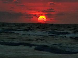 a sunset over the ocean with a red sky at Cabaña Villa July in Moñitos