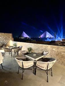 a group of tables and chairs on a patio at night at Casa pyramids hotel in Cairo