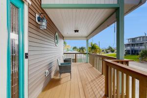 a porch with a chair on a wooden deck at Diversity in Saint James City