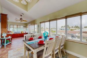 a dining room with a table and chairs and windows at Diversity in Saint James City
