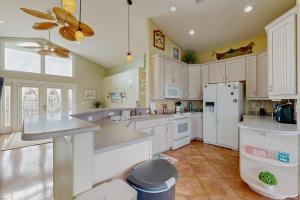 a kitchen with white cabinets and a white refrigerator at Diversity in Saint James City +14 photos