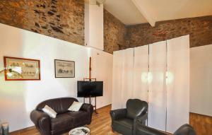 a living room with two leather chairs and a television at Apaisante Villa Piscine in Taulis