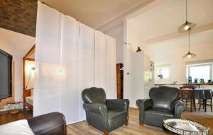 a living room with two chairs and a wall at Apaisante Villa Piscine in Taulis