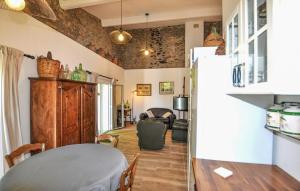 a living room with a table and a refrigerator at Apaisante Villa Piscine in Taulis +10 photos