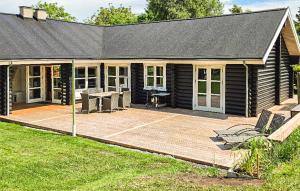 a screened in porch of a house with a picnic table at Lovely Home In Stege With Sauna in Stege
