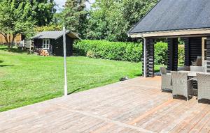 a wooden deck with chairs and a gazebo at Lovely Home In Stege With Sauna in Stege +18 photos