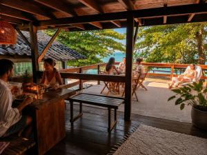 a group of people sitting at a table on a deck at Monkey beach agroturismo in Gamboa