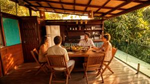 a group of people sitting around a table on a deck at Monkey beach agroturismo in Gamboa