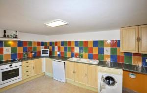 a kitchen with colorful tiles on the wall at Charmante Villa Piscine in Taulis