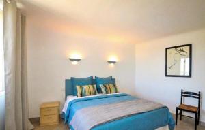 a bedroom with a blue bed and a chair at Charmante Villa Piscine in Taulis