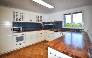 a kitchen with white cabinets and a wooden counter top at Imprenable Villa Piscine in Taulis